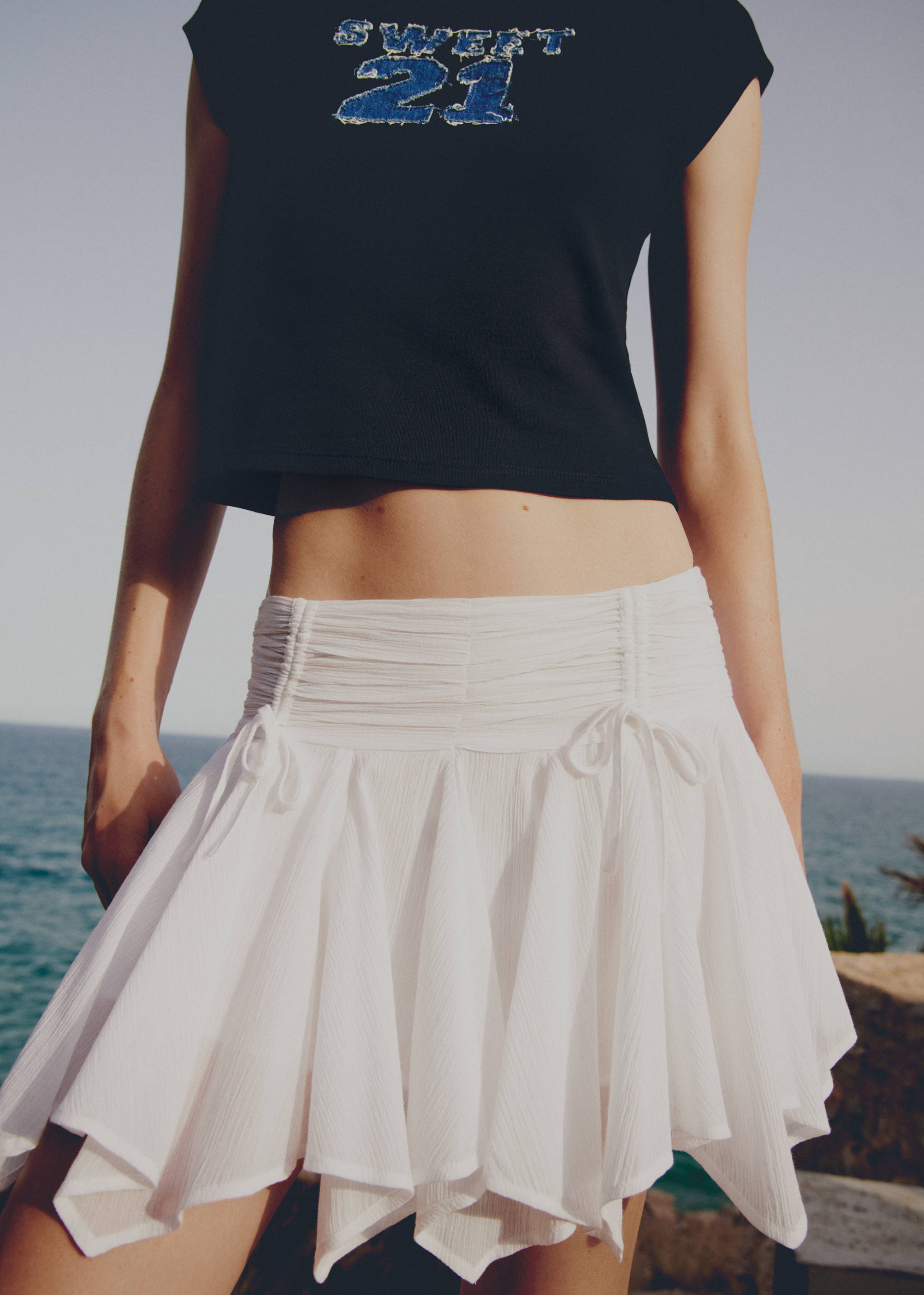 带蝴蝶结的不对称迷你裙 - null