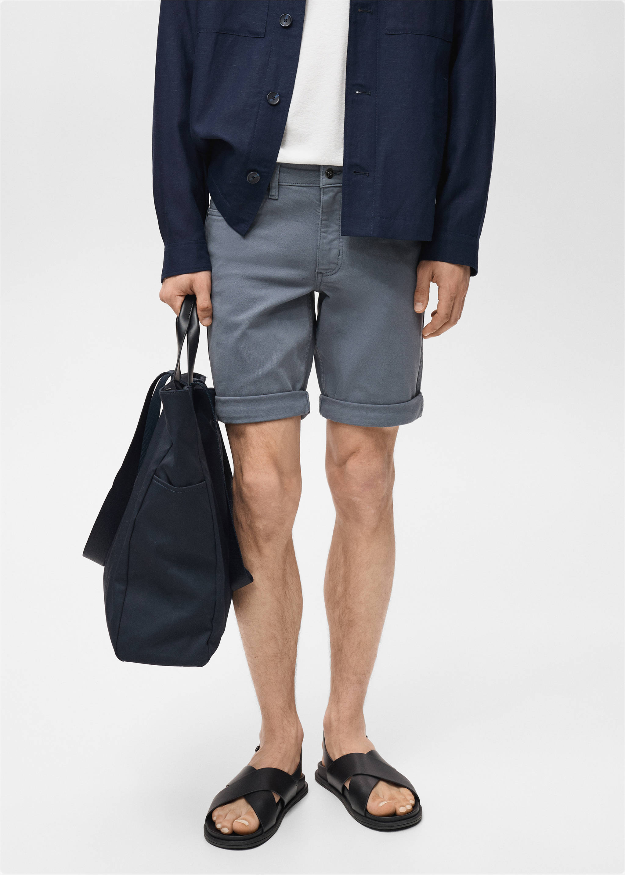 Blue-grey bermuda shorts with cuffed hems, worn with a dark overshirt and sandals., Indigo Blue. Ref: 87007893-00.