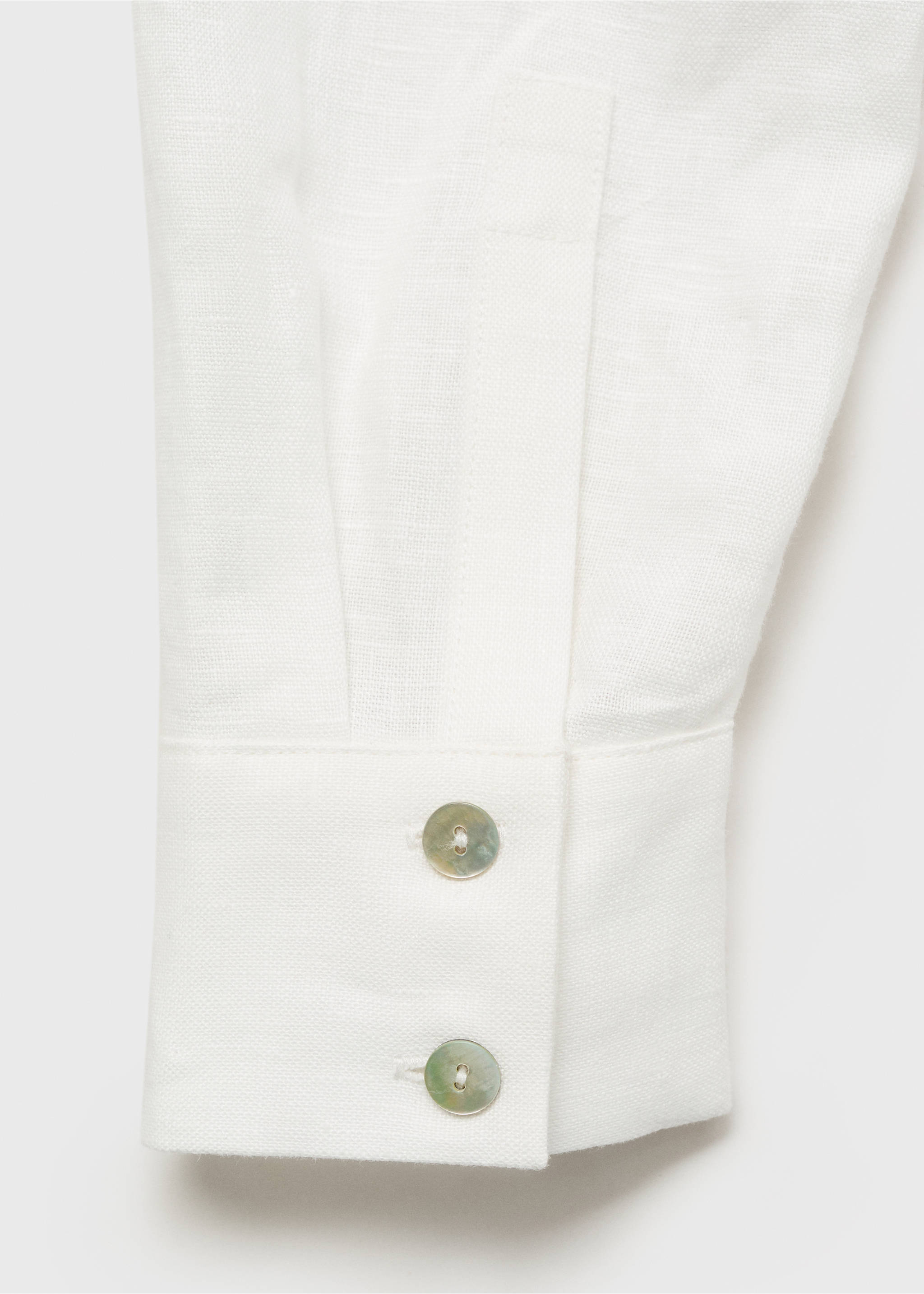 White dress fabric detail showing a buttoned sleeve cuff., White. Ref: 87017166-00.