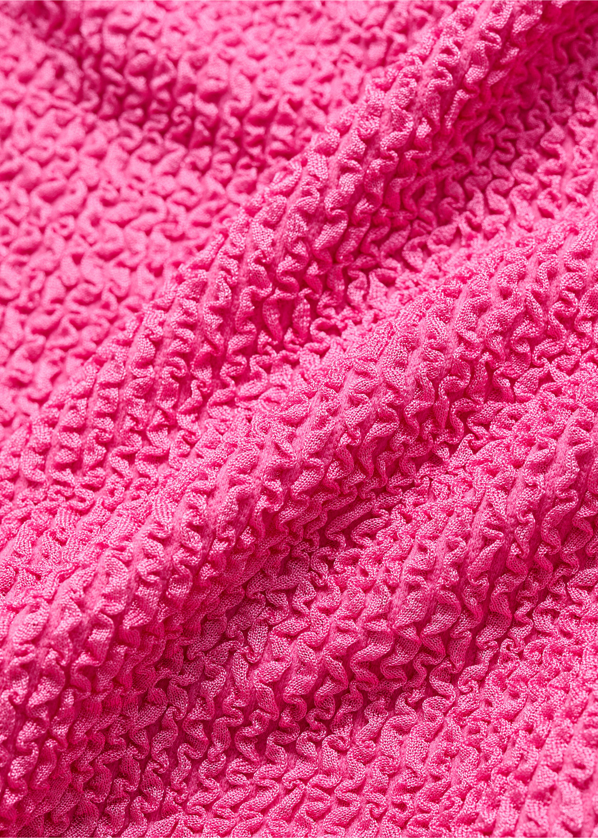 Close-up of bright pink swimsuit fabric with a textured crinkled finish., Pink. Ref: 87049209-00.