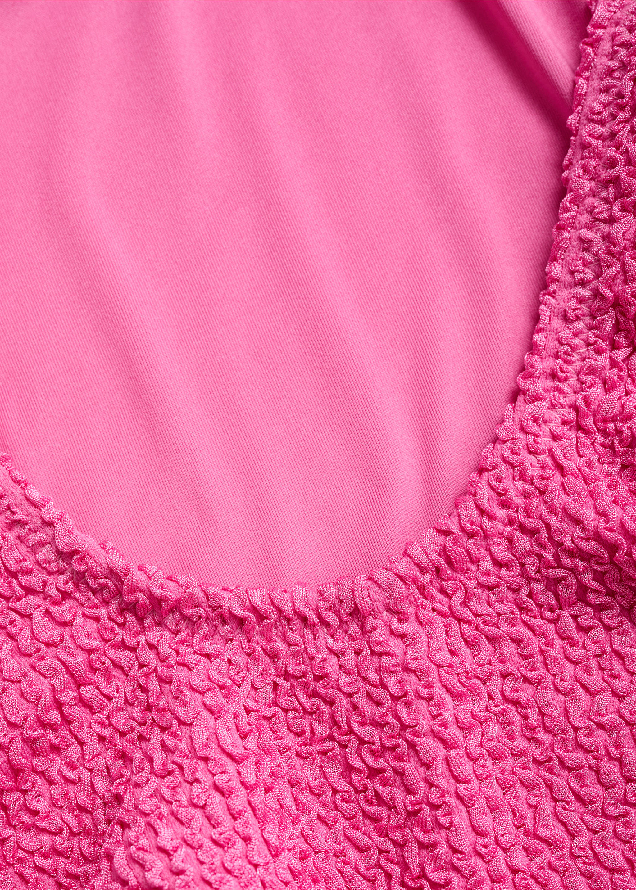 Close-up of the textured fabric detail on a bright pink swimsuit., Pink. Ref: 87049209-00.