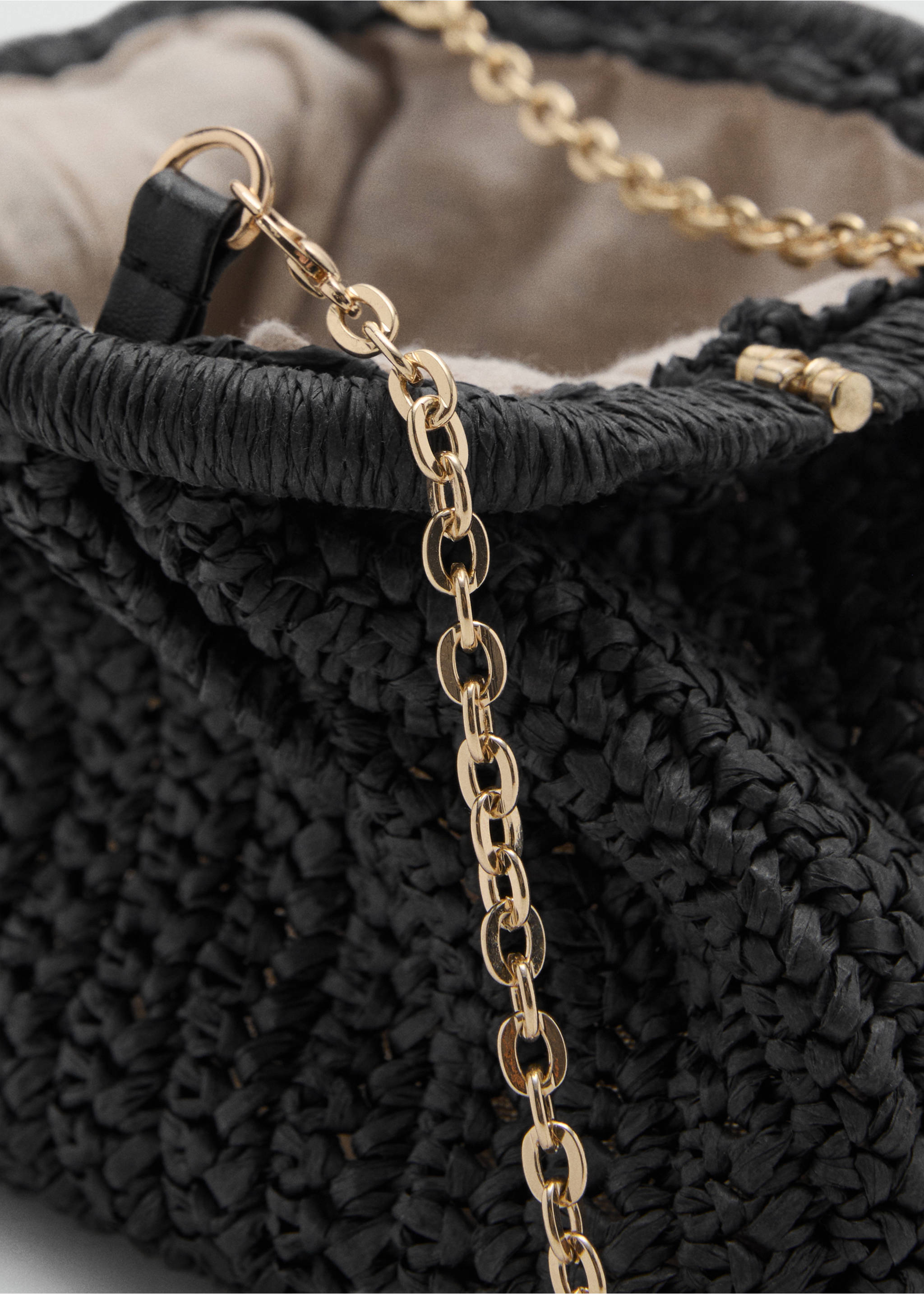 Close-up of a black woven crossbody bag with a gold chain strap., Black. Ref: 87065921-00.