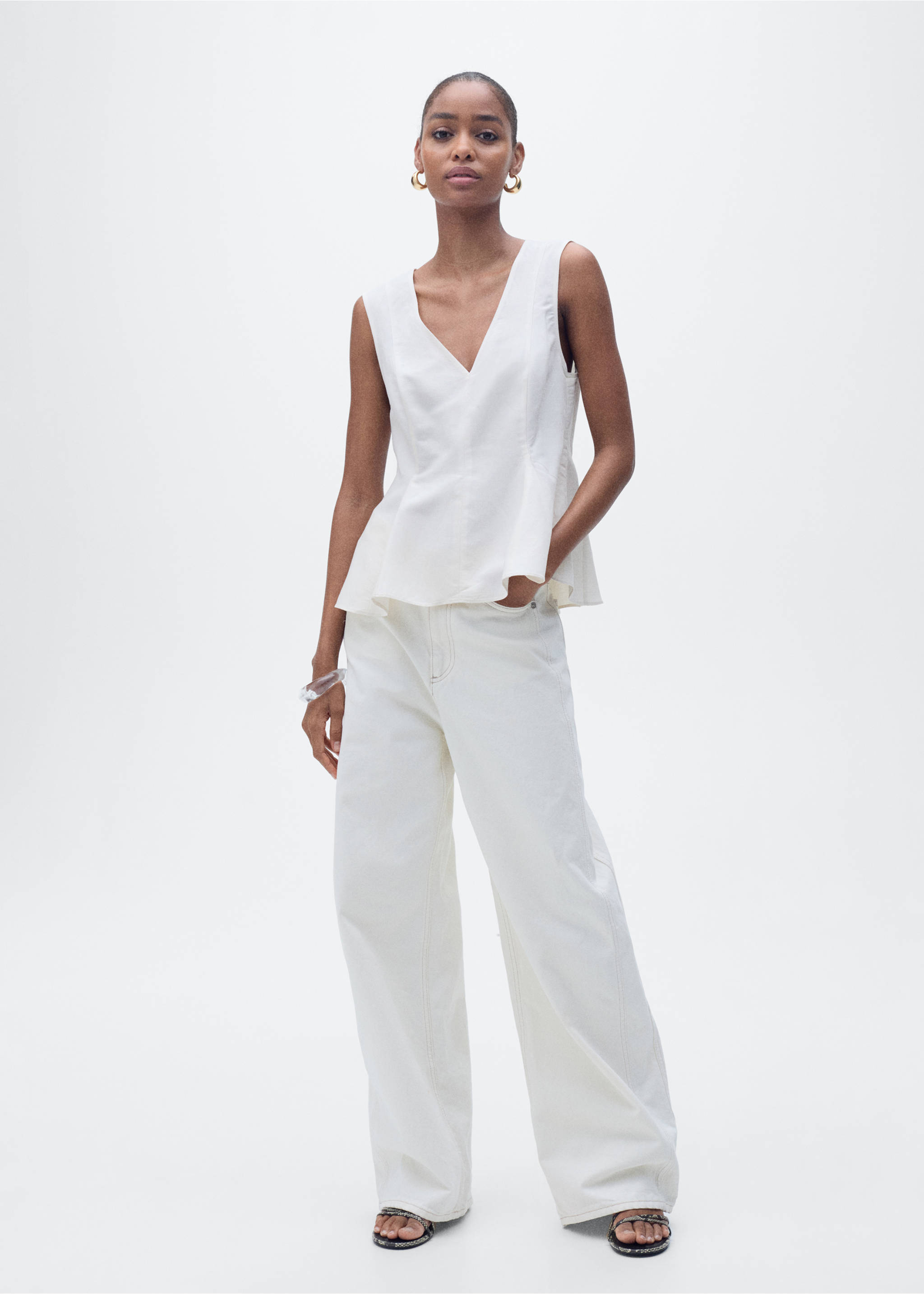 White sleeveless V-neck top with a peplum hem, worn with wide-leg trousers., Ecru. Ref: 87067179-00.