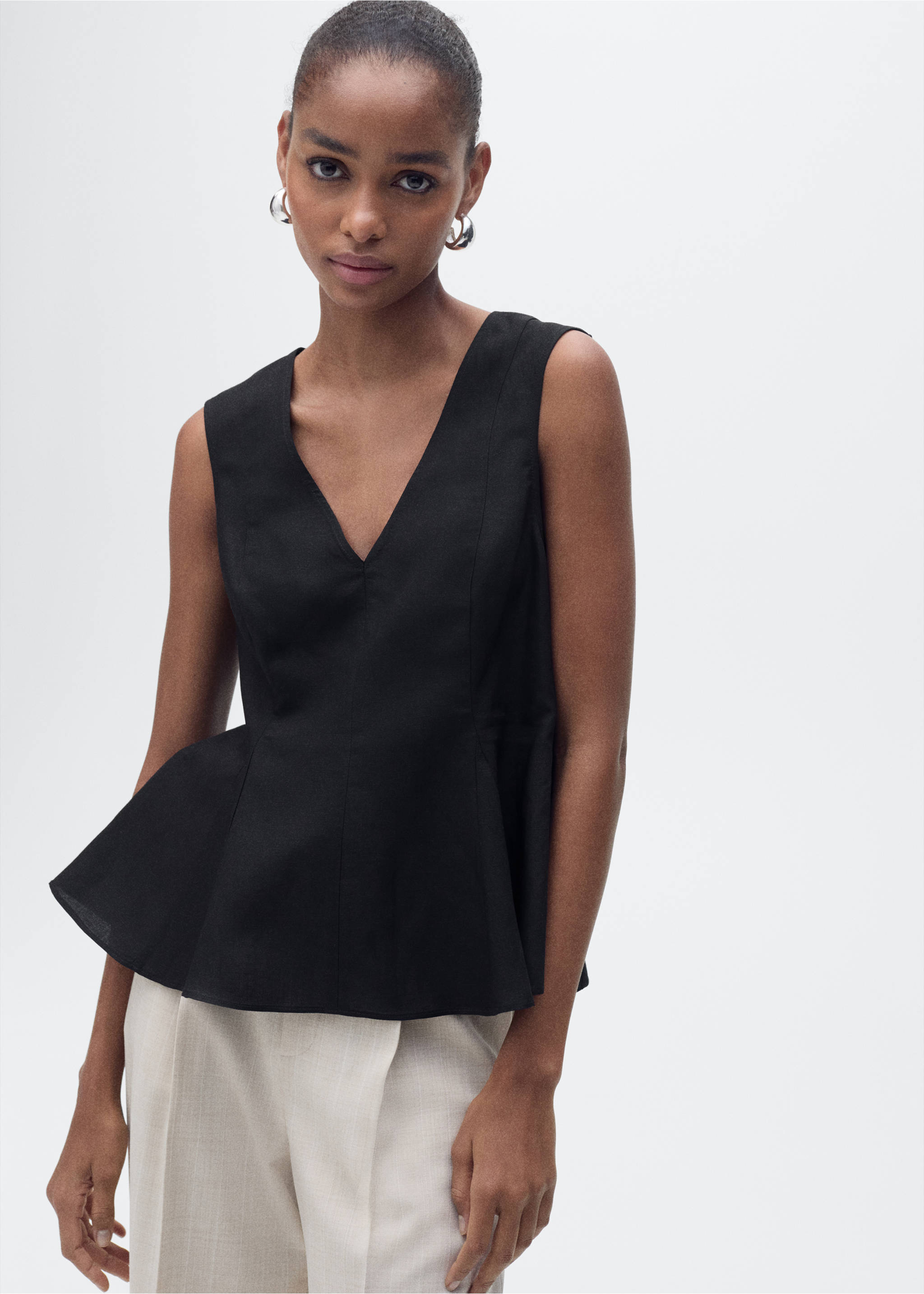 Black sleeveless V-neck top with a flared peplum hem., Black. Ref: 87067179-00.