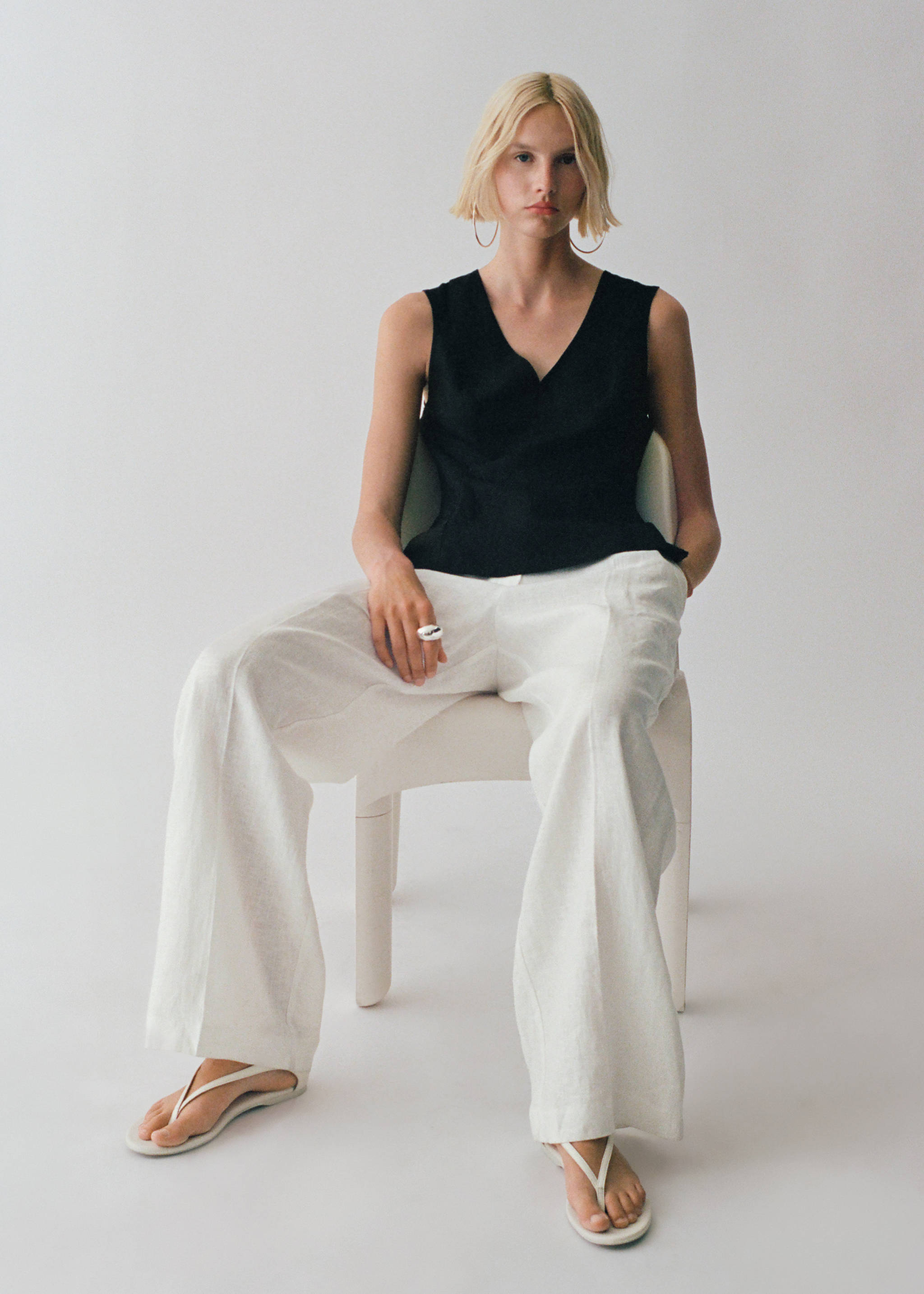 Black sleeveless V-neck top worn with white trousers, Black. Ref: 87067179-00.