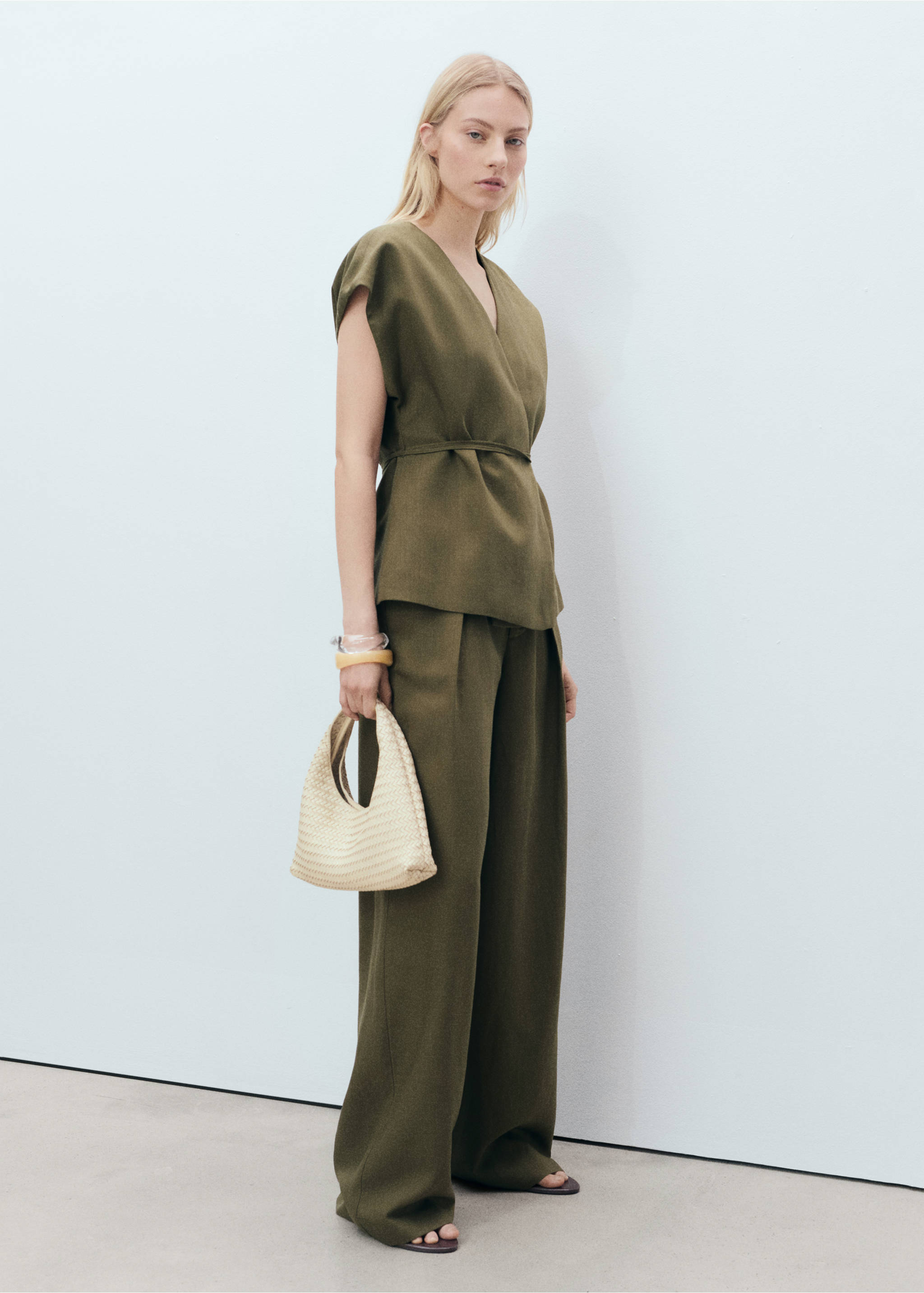 Olive green sleeveless wrap top with V-neckline and tie waist, worn with trousers., Khaki. Ref: 87078640-00.