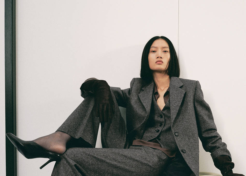 Woman dressed in a suit of white pants and vest