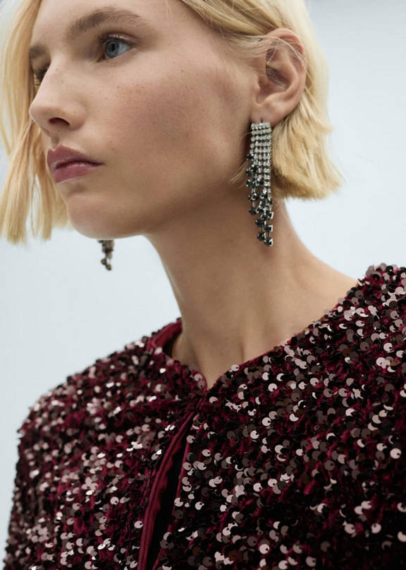 A sequin skirt party outfit and silver earrings.