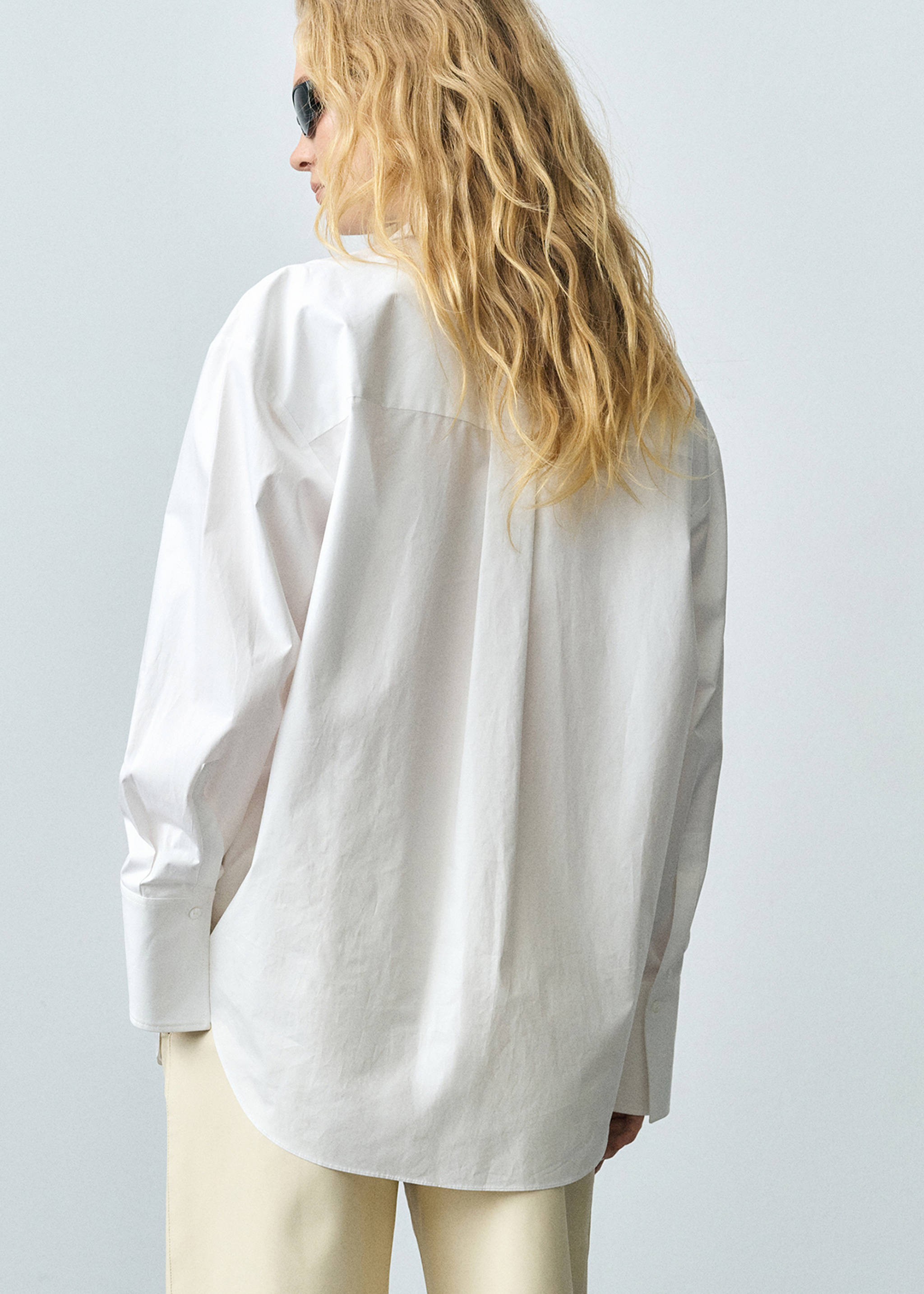 Woman wearing a look with an oversized white shirt.