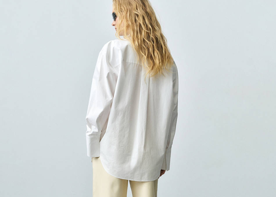 Woman wearing a look with an oversized white shirt.
