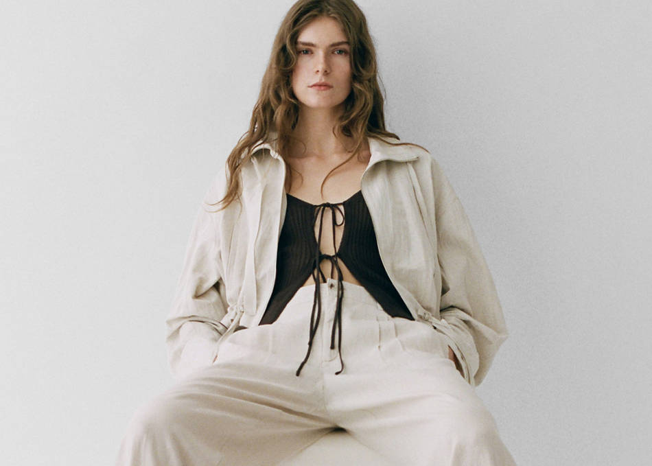 Woman wearing a total look with beige trousers