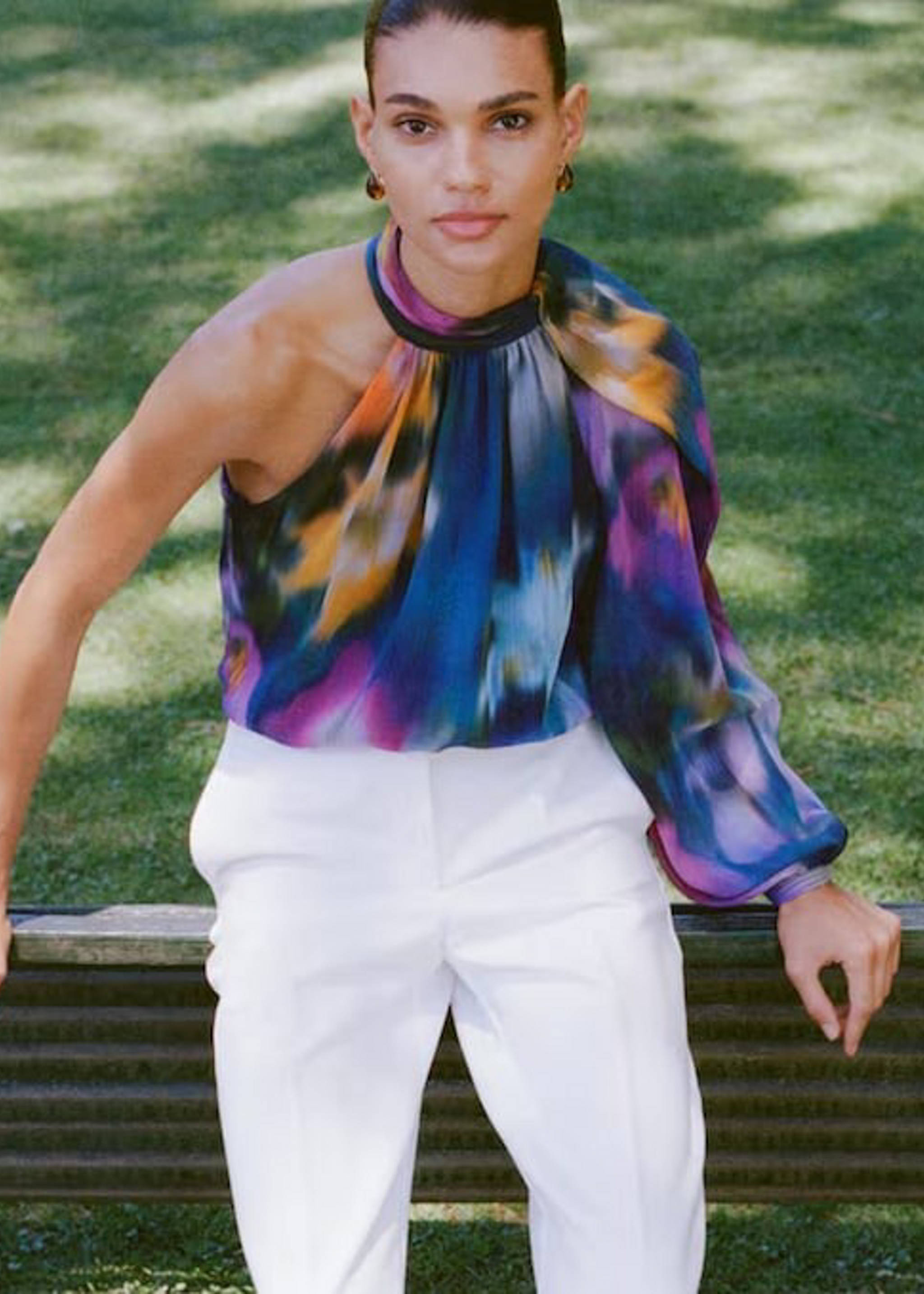 Woman wearing a fur coat and white pants.