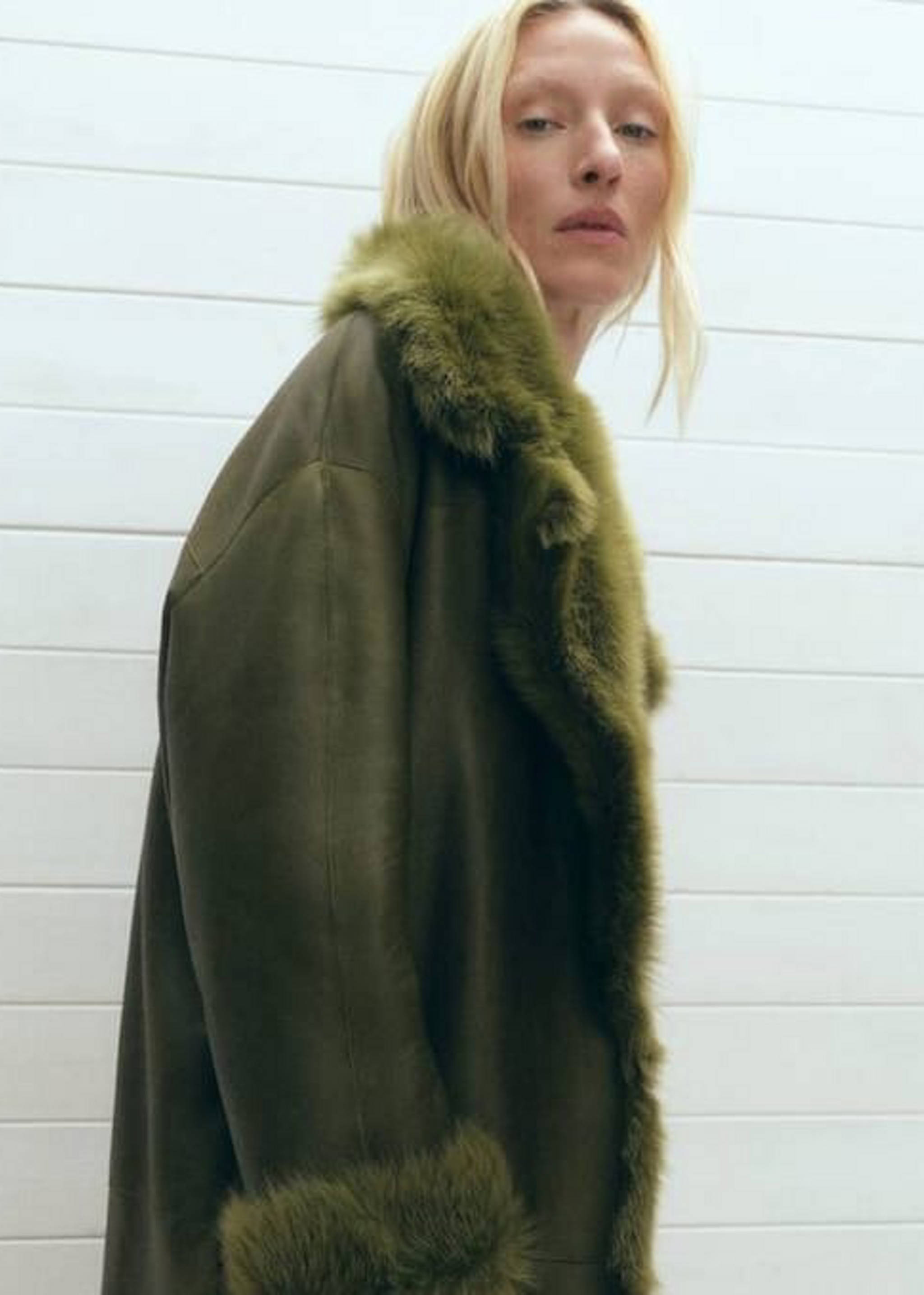 Girl wearing a type of brown coat with white fur.