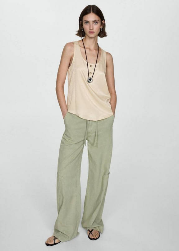 Woman combining beige cargo pants with a green top.