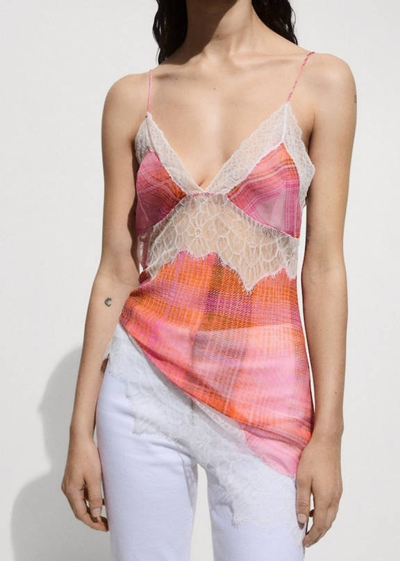 Girl wearing a festival look with a pink lace top and white pants.