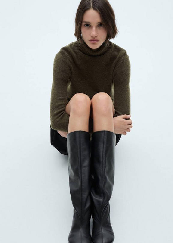 Woman wearing an outfit with high boots and shorts