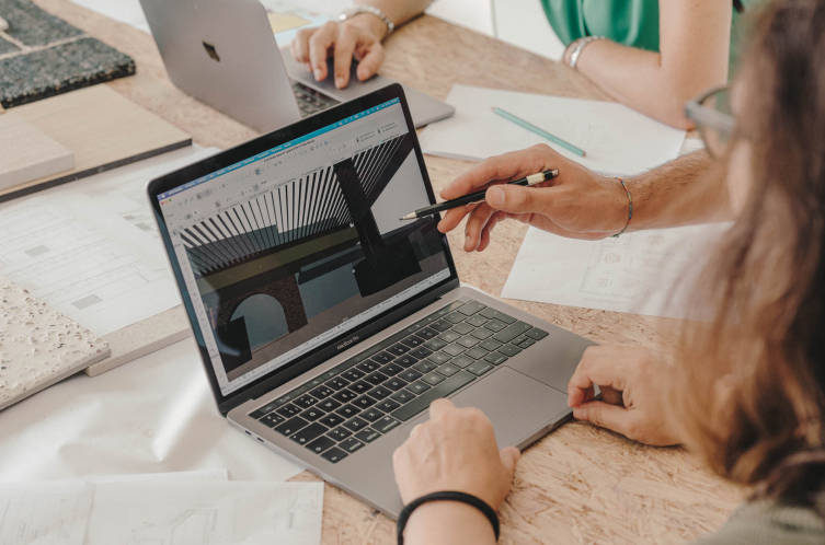 Persona trabajando en documentos financieros en un portátil